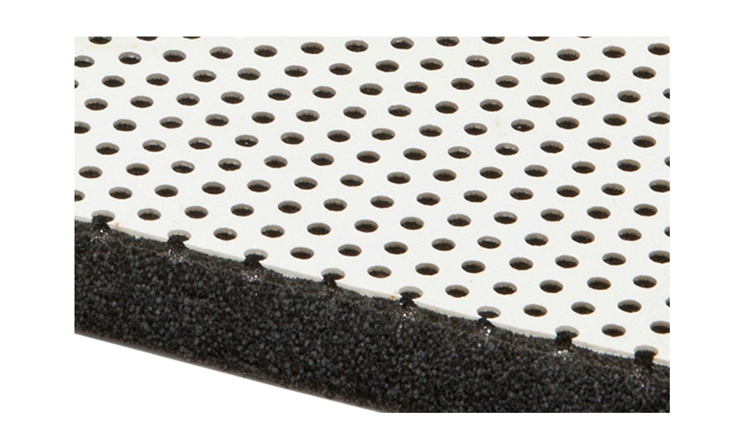 Bildausschnitt des Querschnittes der Schallschutz-Matte 1165A. Im Querschnitt schwarze und auf der Oberfläche weiss mit runden Löchern gestanzt.