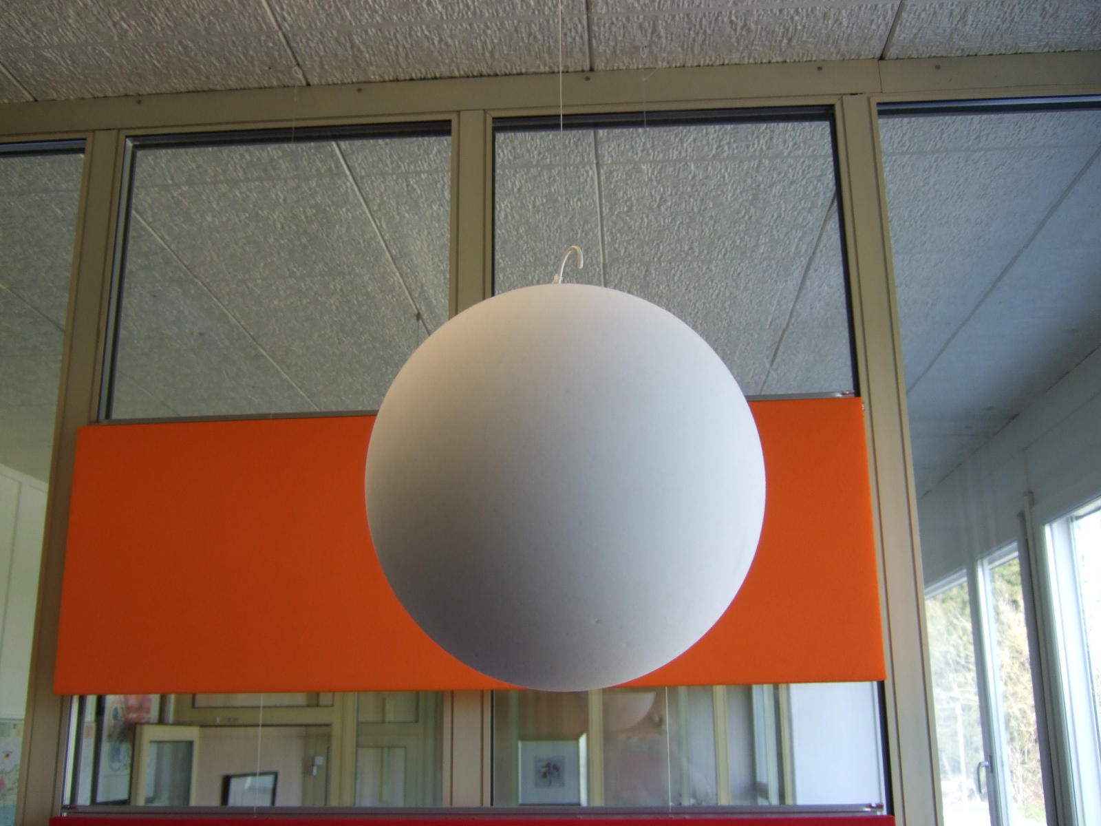 Bild eines weissen runden Balls, der von der Decke hängend als Schalldämpfer im Raum wirkt.